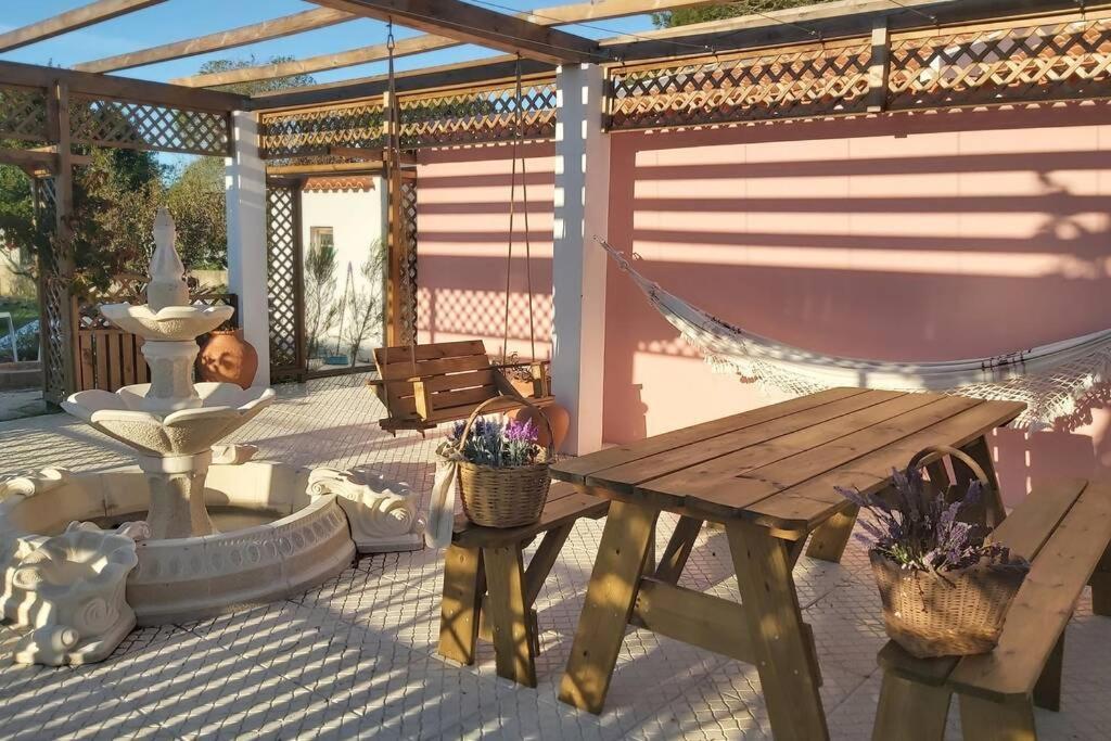 patio con tavolo in legno e amaca di Casa dos Malmequeres a Sintra