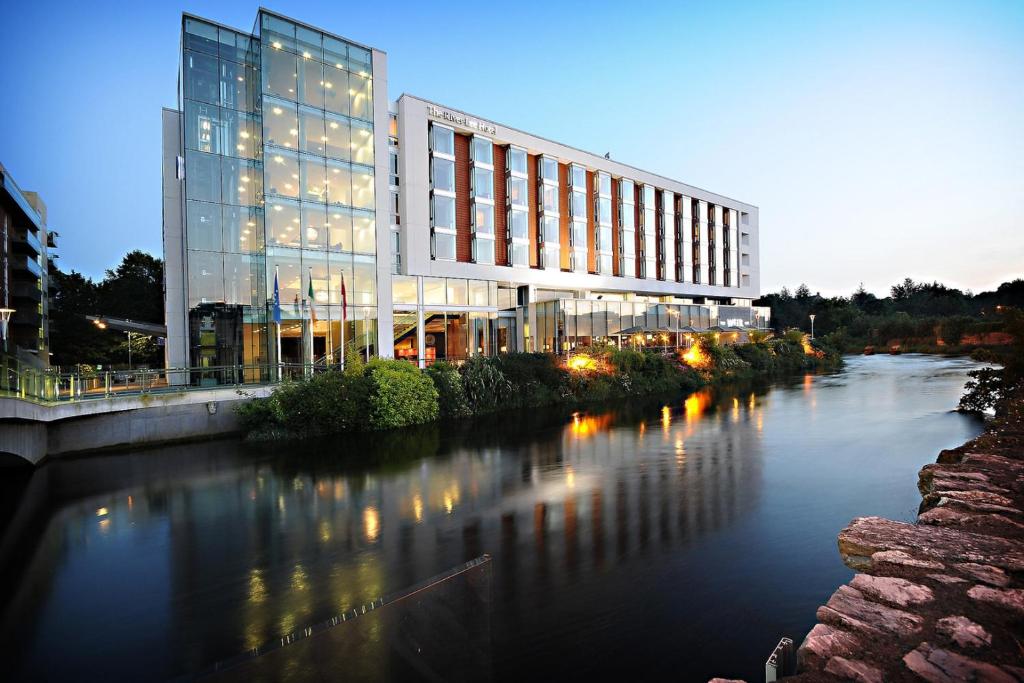 un edificio accanto a un fiume con un edificio di The River Lee Hotel a member of The Doyle Collection a Cork