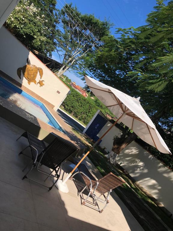 two chairs and an umbrella on a patio at POUSADA CASA SERRA ALVES in Búzios