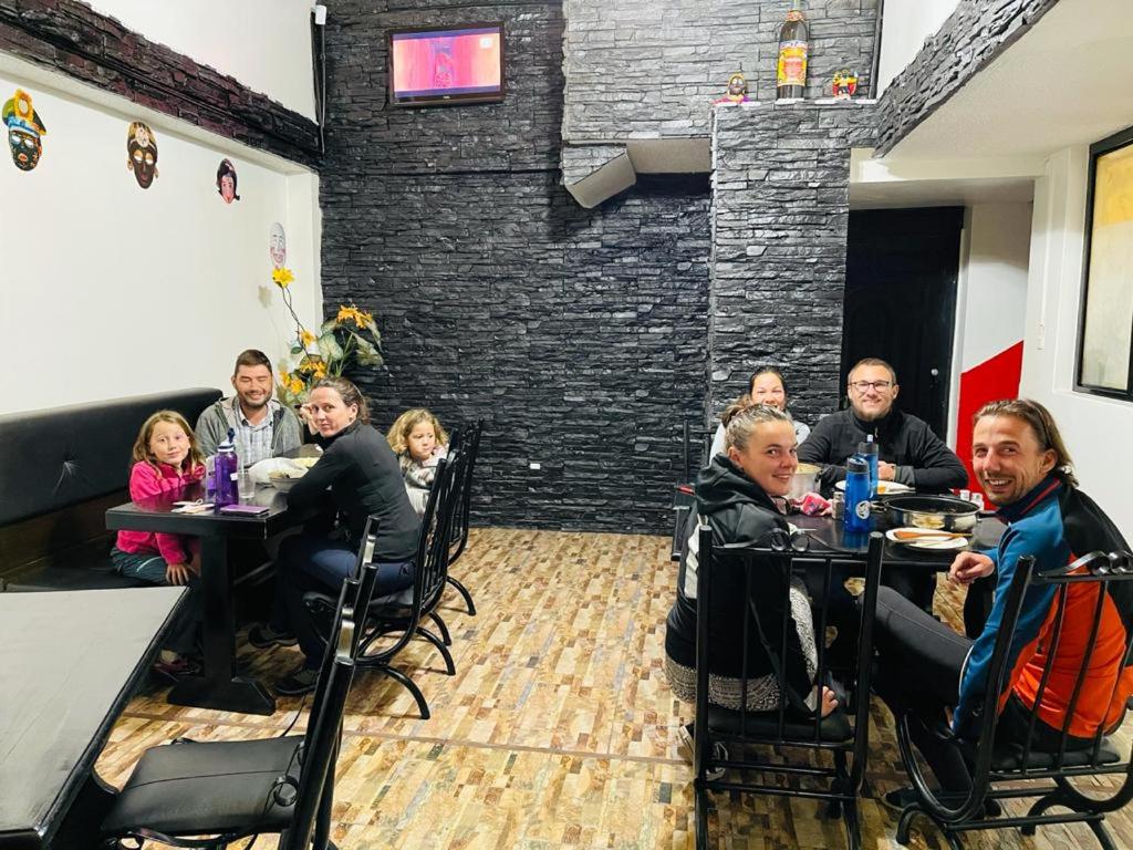 un grupo de personas sentadas en mesas en un restaurante en Hostal Rosita Latacunga en Latacunga