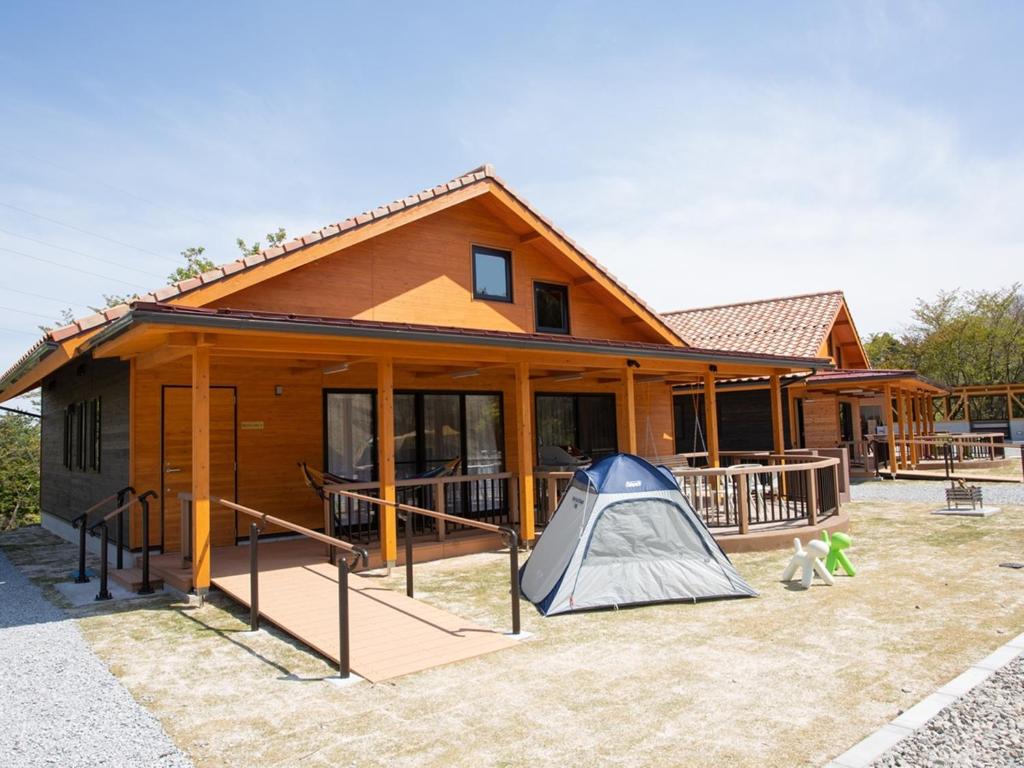 uma casa com uma tenda em frente em Matsue Forest Park em Matsue