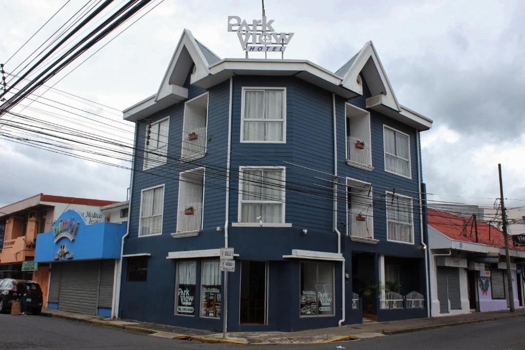 een blauw gebouw met een bord erop bij Park View Hotel & Restaurant in Alajuela