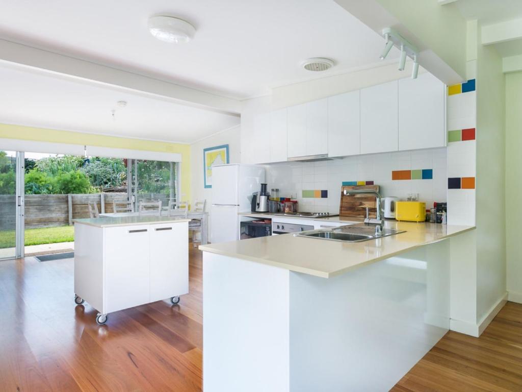 a kitchen with white cabinets and a counter top at Summer In Blairgowrie in Blairgowrie