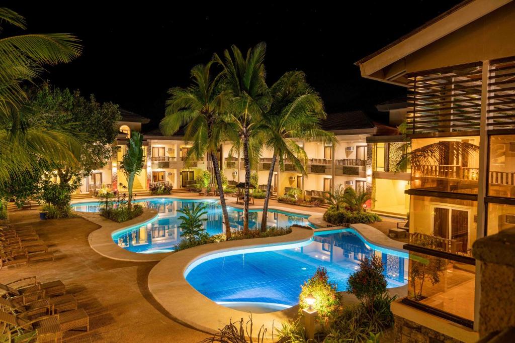 una imagen de una piscina del complejo por la noche en MO2 Westown Lagoon Coron, en Corón