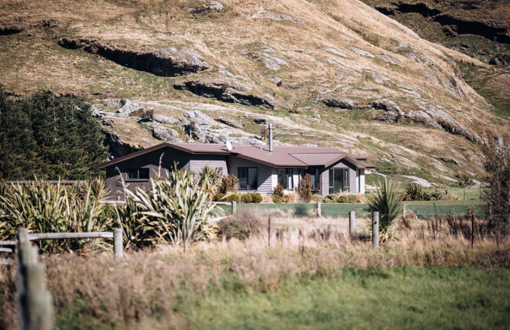 une maison en face d'une montagne dans l'établissement Matukituki Lodge, à Wanaka