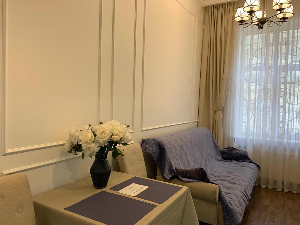 a living room with a table with a vase of flowers at LUX APARTAMENT на Левицького in Lviv