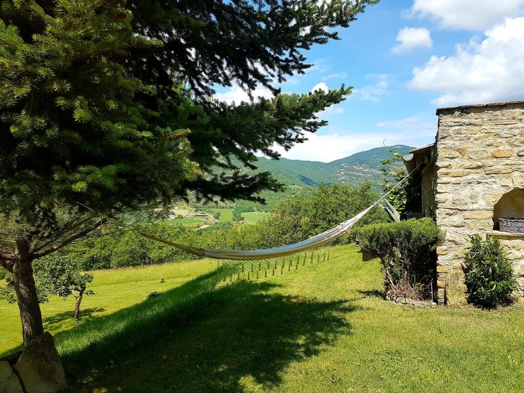 una hamaca en un campo junto a un edificio en Charmant appartement dans corps de ferme AIGLUN, en Aiglun