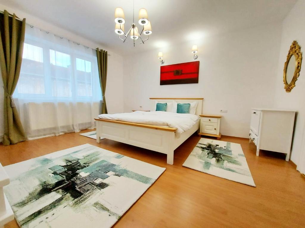 ブラショヴにあるCasa Dușa - Apartament Crisstinaのベッドルーム1室(ベッド1台付)、床に敷物2枚が備わります。
