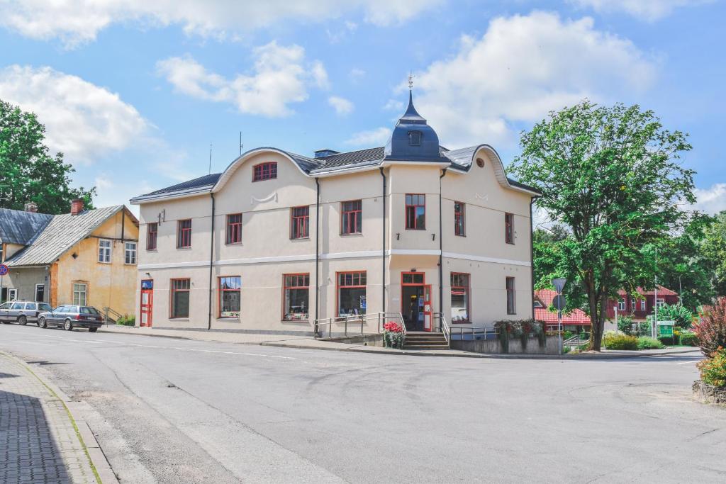 a large white building on the side of a street at Hostel Nr.2 in Rauna