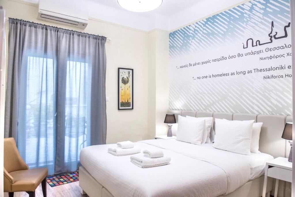 una camera da letto con un grande letto bianco con asciugamani di #Nephele & Morpheus Studios by halu! a Salonicco