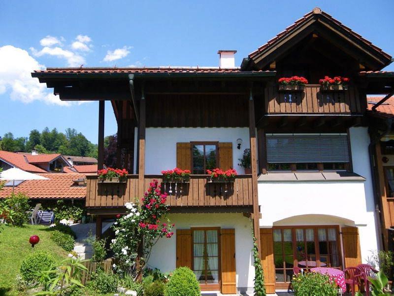 een huis met bloembakken op het balkon bij Ferienwohnung Hinterstoißer in Berchtesgaden
