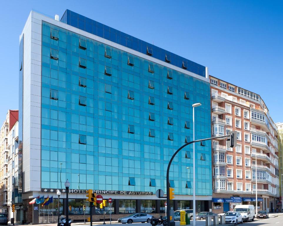 un grande edificio in vetro su una strada cittadina di Hotel Príncipe de Asturias a Gijón