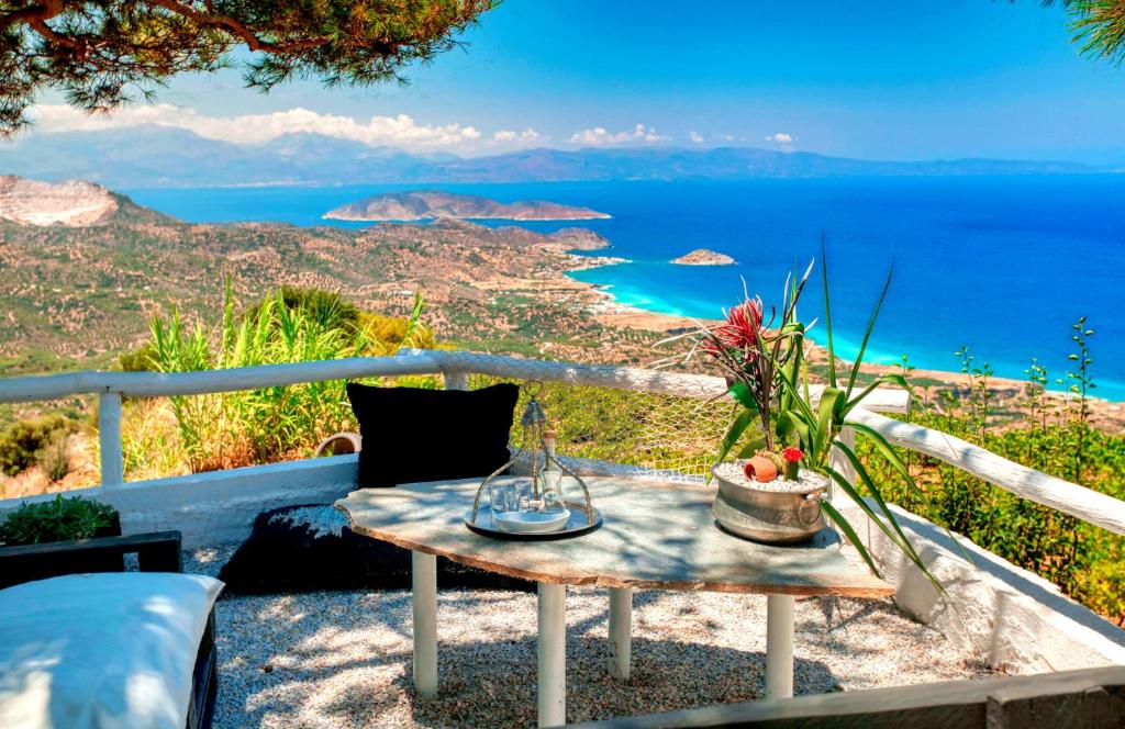 Epavlis في Mirsíni: طاولة مع مزهرية وزهور على شرفة مع المحيط