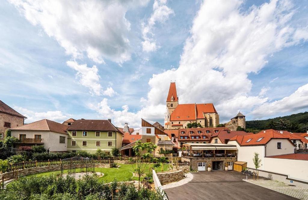 grupa budynków w mieście z kościołem w obiekcie Hotel-Restaurant Kirchenwirt w mieście Weissenkirchen in der Wachau