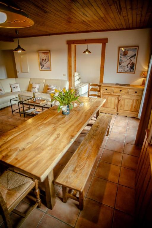 - une grande table en bois dans le salon dans l'établissement L Aravis (Gite des Alpes), à La Giettaz