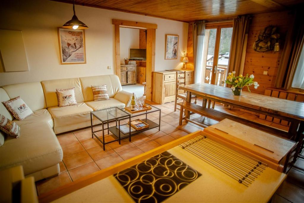 sala de estar con sofá y mesa en L Aravis (Gite des Alpes), en La Giettaz