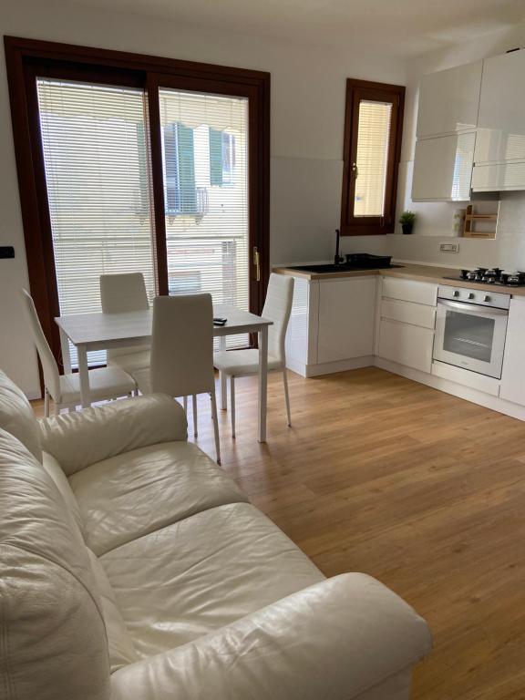een woonkamer met een witte bank en een tafel bij Ada's House in Alghero