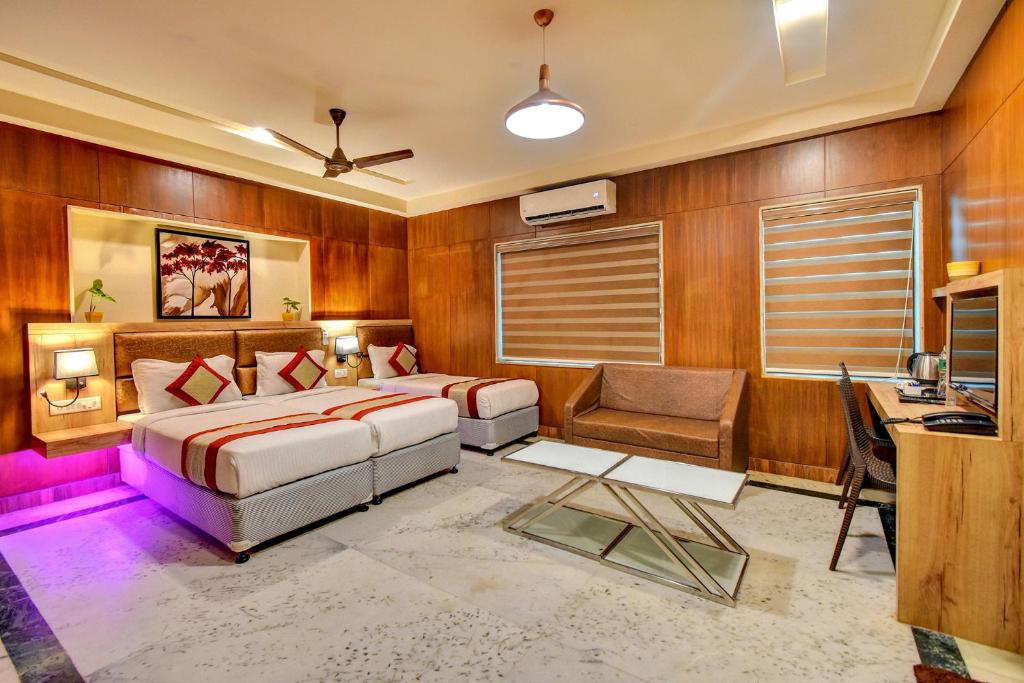a bedroom with a bed and a desk and a chair at FabHotel Nestlay Rooms Airport in Chennai