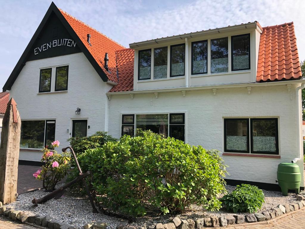 ein weißes Haus mit orangefarbenem Dach in der Unterkunft Pension Even Buiten in Burgh Haamstede