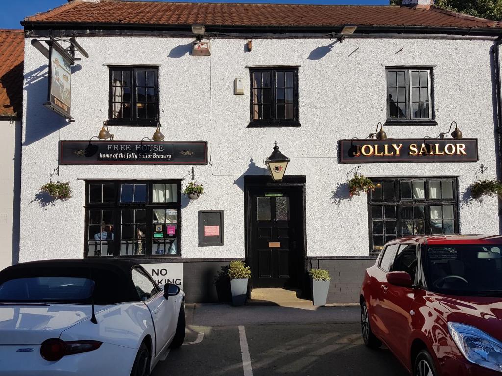 un bâtiment blanc avec des voitures garées devant lui dans l'établissement Jolly Sailor, à Cawood