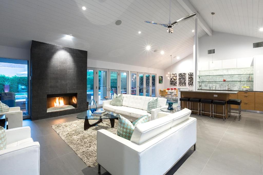 a living room with white furniture and a fireplace at Villa Tranquilo home in Palm Springs