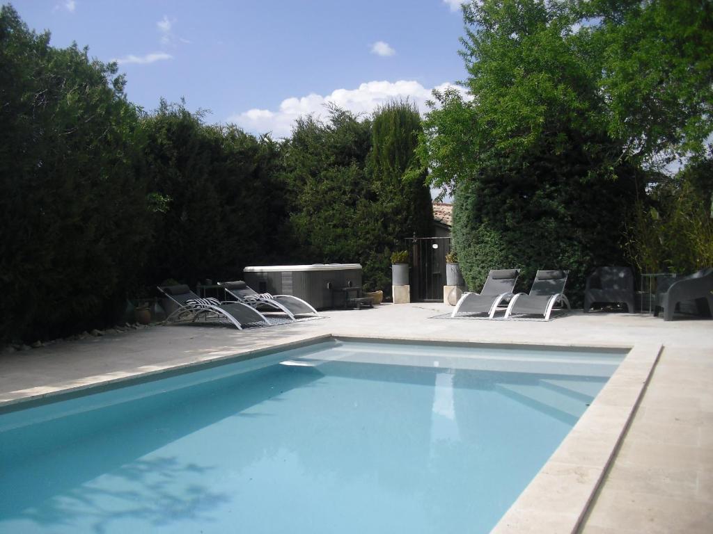 MéthamisにあるGîte de charme piscine et SPA en Provenceのラウンジチェア付きのスイミングプールが隣接しています。