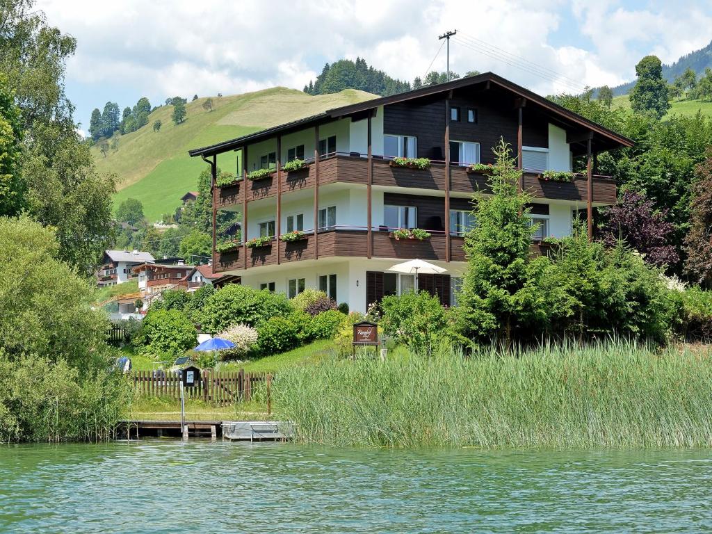 uma casa grande ao lado de um lago em Rosenhof am See Ferienwohnung Alpenglühen em Thiersee