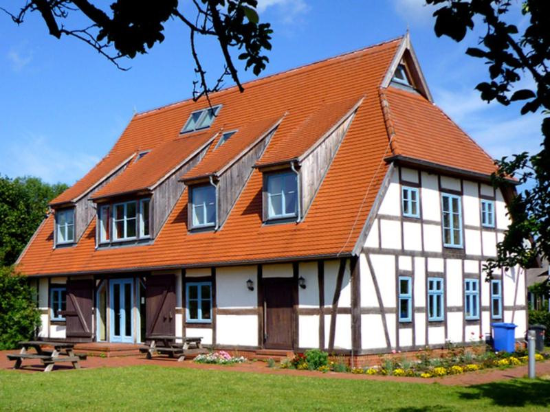 une grande maison avec un toit orange dans l'établissement Eulenhof, 