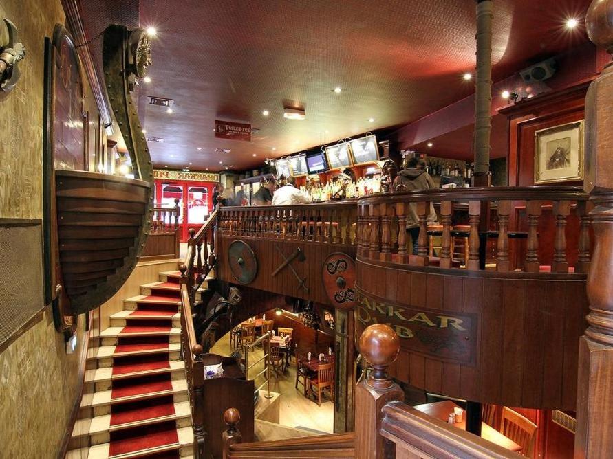 a view of a restaurant with a staircase and a bar at Logis Hôtel Restaurant Le Drakkar in Mende