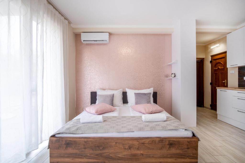 希歐福克的住宿－MF Siófok Beach Wellness Apartment，卧室配有一张带粉红色枕头的大床