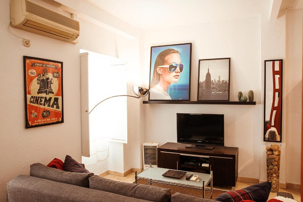 Il comprend un salon doté d'un canapé et d'une télévision à écran plat. dans l'établissement RentalSevilla Precioso apartamento reformado en la Alameda, à Séville