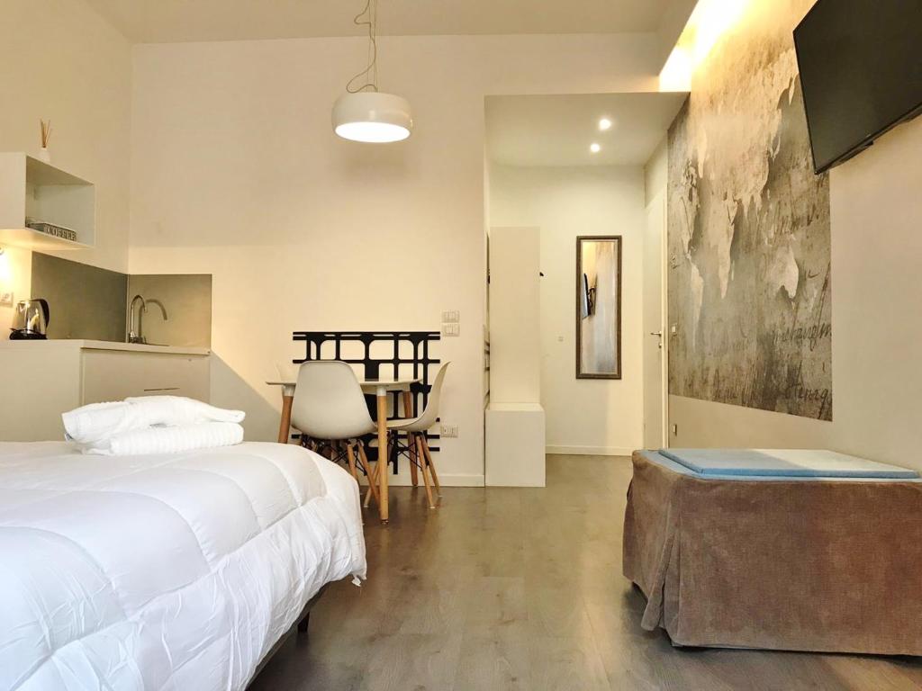 ein Schlafzimmer mit einem Bett und einem Tisch sowie eine Küche in der Unterkunft Angolo di Ninno in Matera