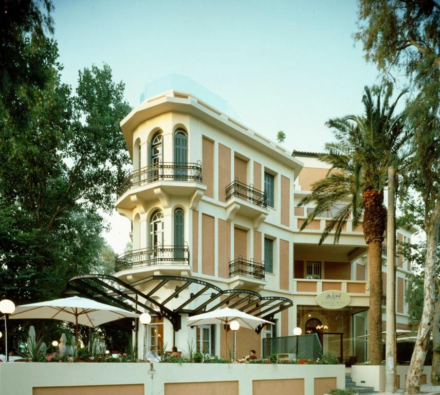 a large building with balconies and umbrellas in front of it at The Kefalari Suites in Athens