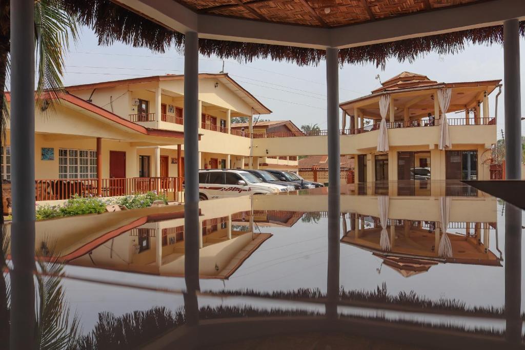 a reflection of a house and a boat in the water at Paloma Guest House in Kenema