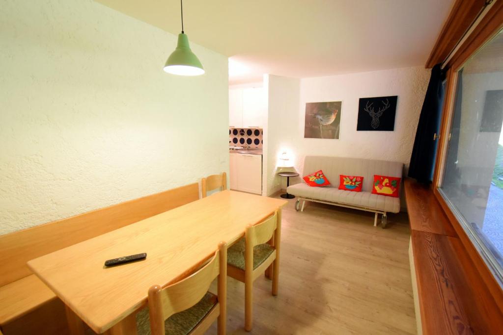 - une salle à manger avec une table en bois et un canapé dans l'établissement Rainalter 06, à Madonna di Campiglio