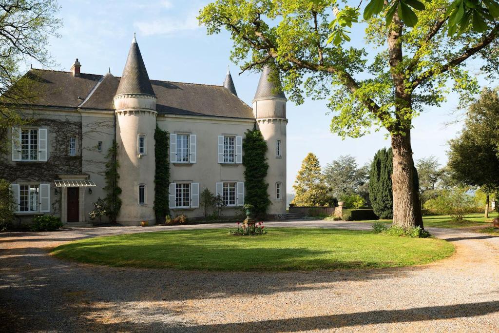 un viejo castillo con un árbol delante de él en Château Haute Roche en Oudon