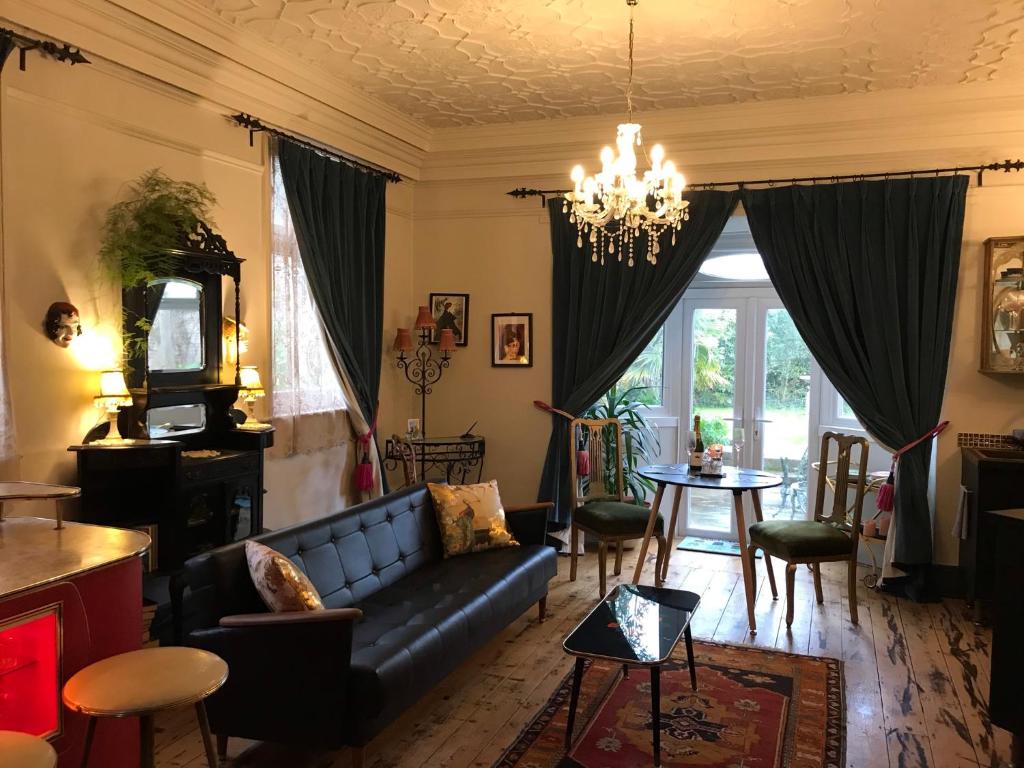 uma sala de estar com um sofá e uma mesa em Pretty Victorian Garden Flat em Radipole