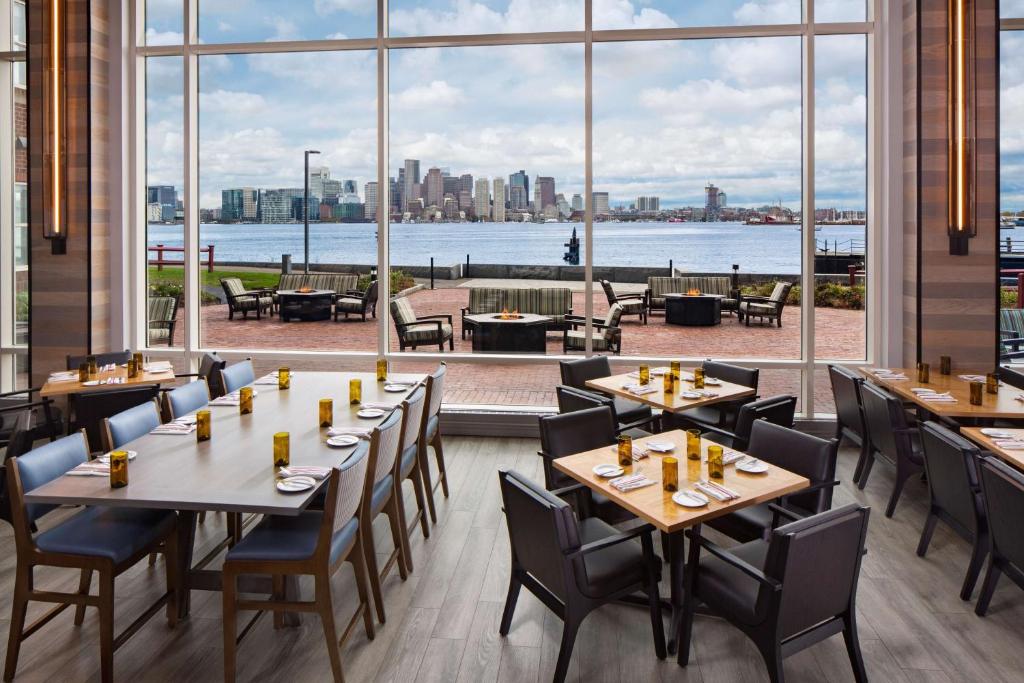 a restaurant with tables and chairs and a large window at Hyatt Regency Boston Harbor in Boston