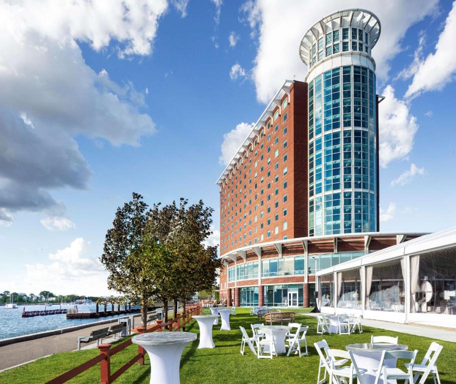 a hotel with tables and chairs in front of a building at Hyatt Regency Boston Harbor in Boston
