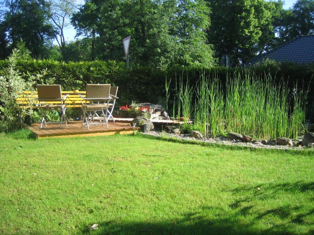 einen Hof mit zwei Stühlen und einem Tisch im Gras in der Unterkunft Ferienwohnung Sonnengelb in Schwielowsee