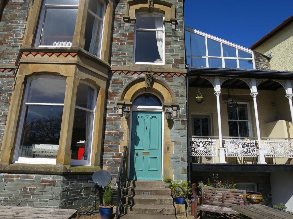 a brick house with a turquoise door at Fitz House in Keswick