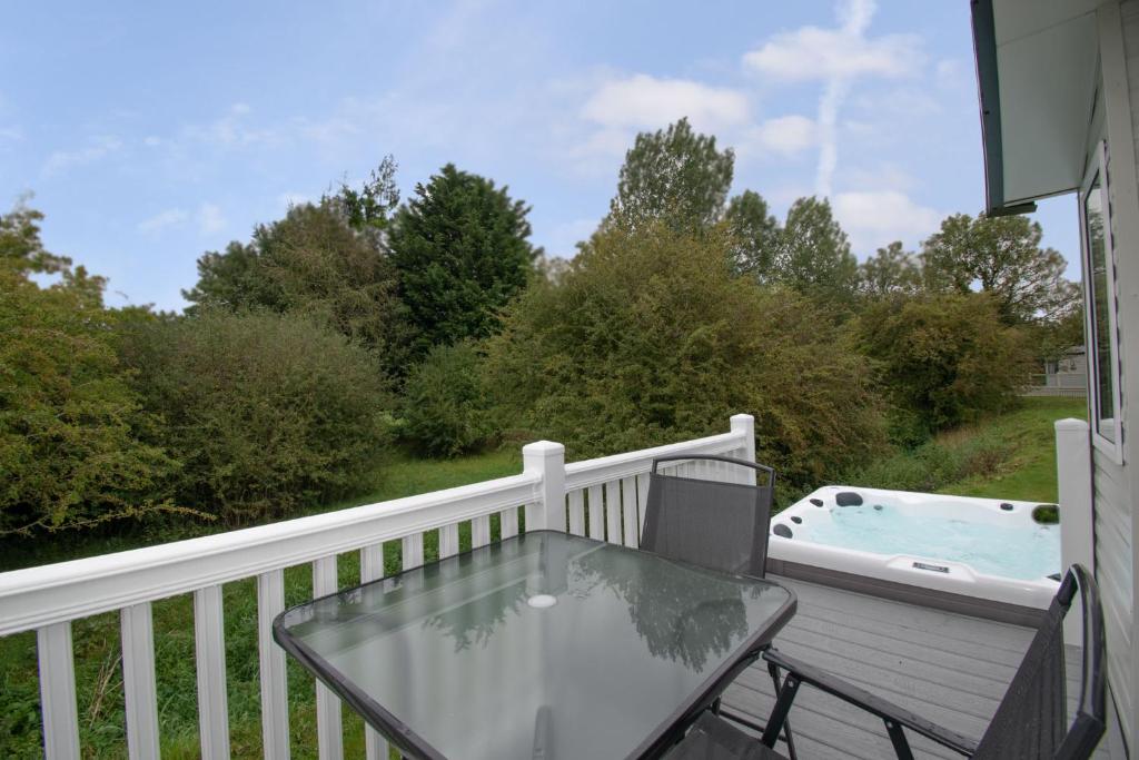 a balcony with a glass table and a hot tub at Yorkshire Lodge with Hot Tub in York
