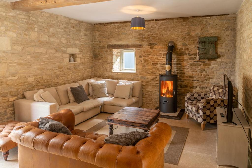 a living room with a couch and a fireplace at Middle Barn in Dyrham