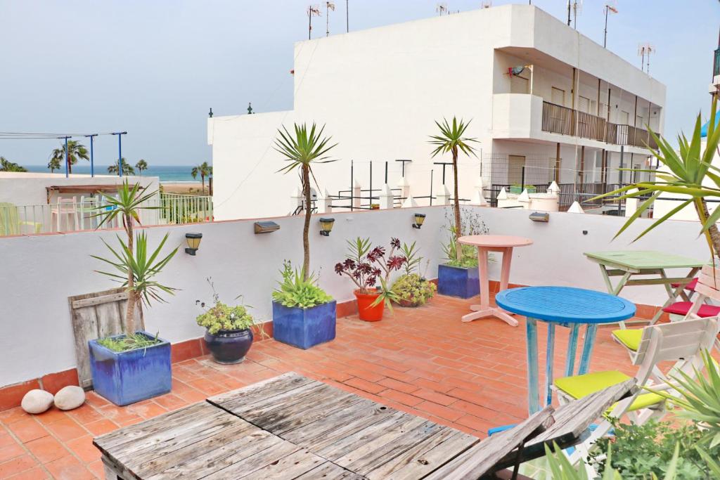 un patio con mesa, sillas y plantas en Habitación Cañaveral Playa Conil IV, en Conil de la Frontera