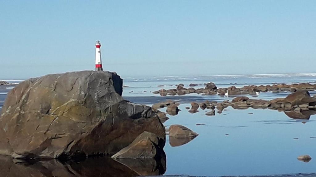 a lighthouse sitting on top of a rock in the water at Nelikko ja riihisauna , juhla- majoitustilat in Himanka