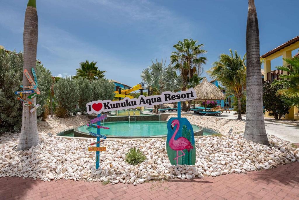 ウィレムスタッドにあるKunuku Resort All Inclusive Curacao, Trademark by Wyndhamのスイミングプールと看板のあるリゾート