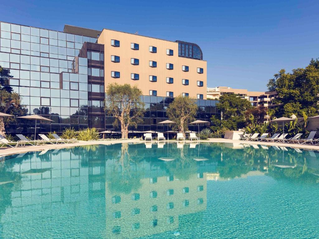 una grande piscina d'acqua di fronte a un edificio di Mercure Villa Romanazzi Carducci Bari a Bari