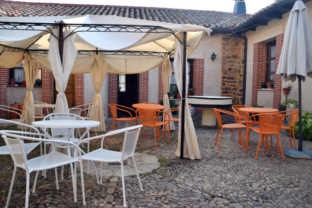 um grupo de mesas e cadeiras sob um guarda-sol em Casa Rural Molino Del Arriero em Luyego de Somoza