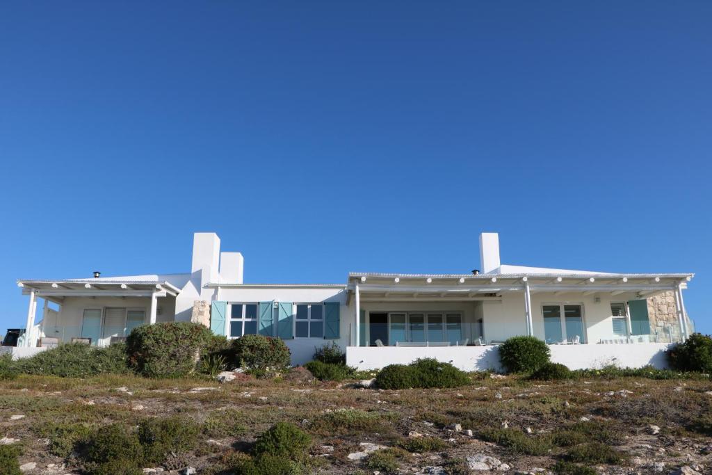a house on top of a grassy field at Dune Ridge Main House in Paternoster
