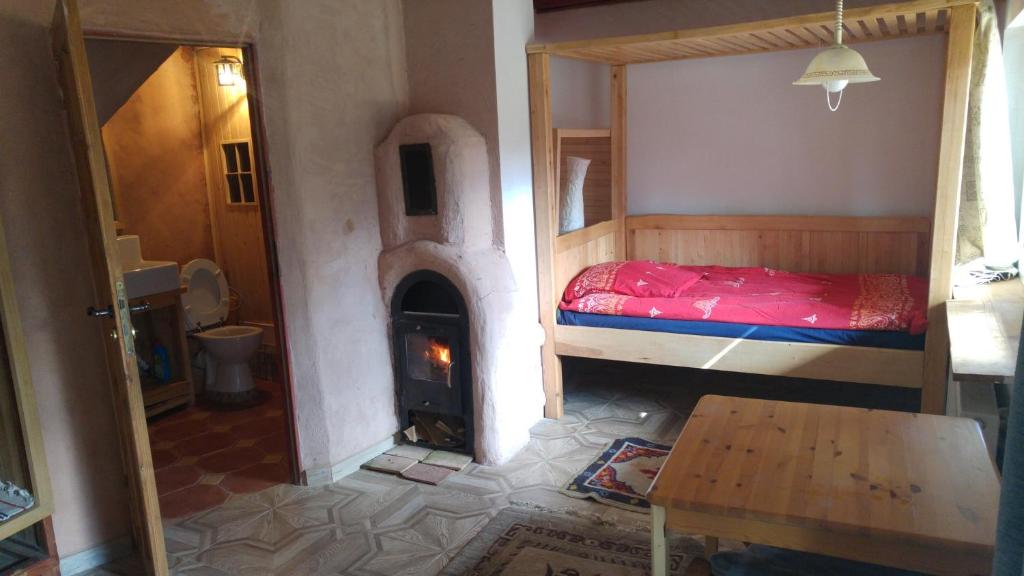 - une chambre avec un lit et une cheminée dans l'établissement Agrochillout Gospodarstwo agroturystyczne, à Zagnańsk Zachełmie